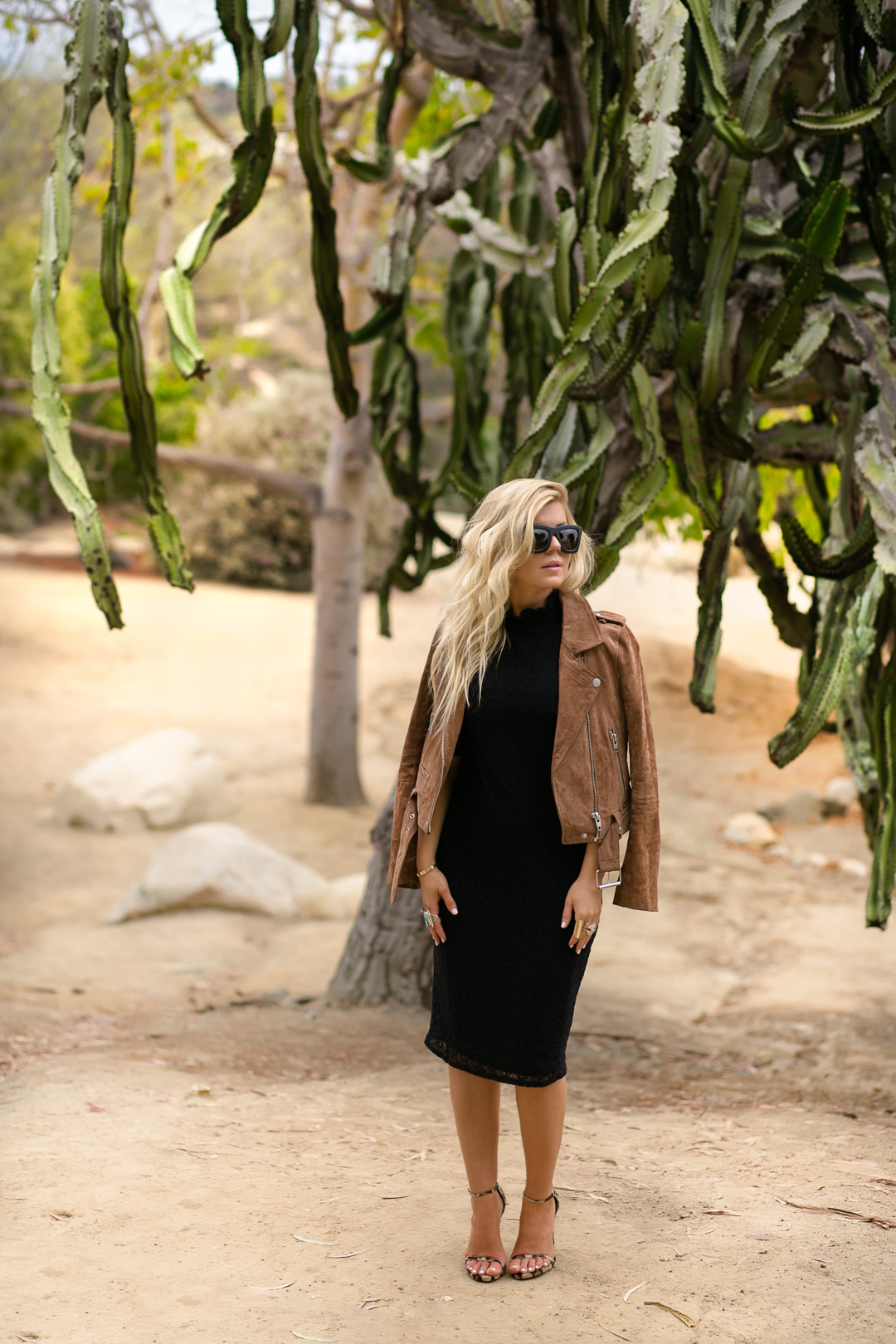 Lisa Allen of LunchPails and Lipstick wearing a BlankNYC suede jacket with a black lace dress and Stuart Weitzman Nudist heels at balboa park.